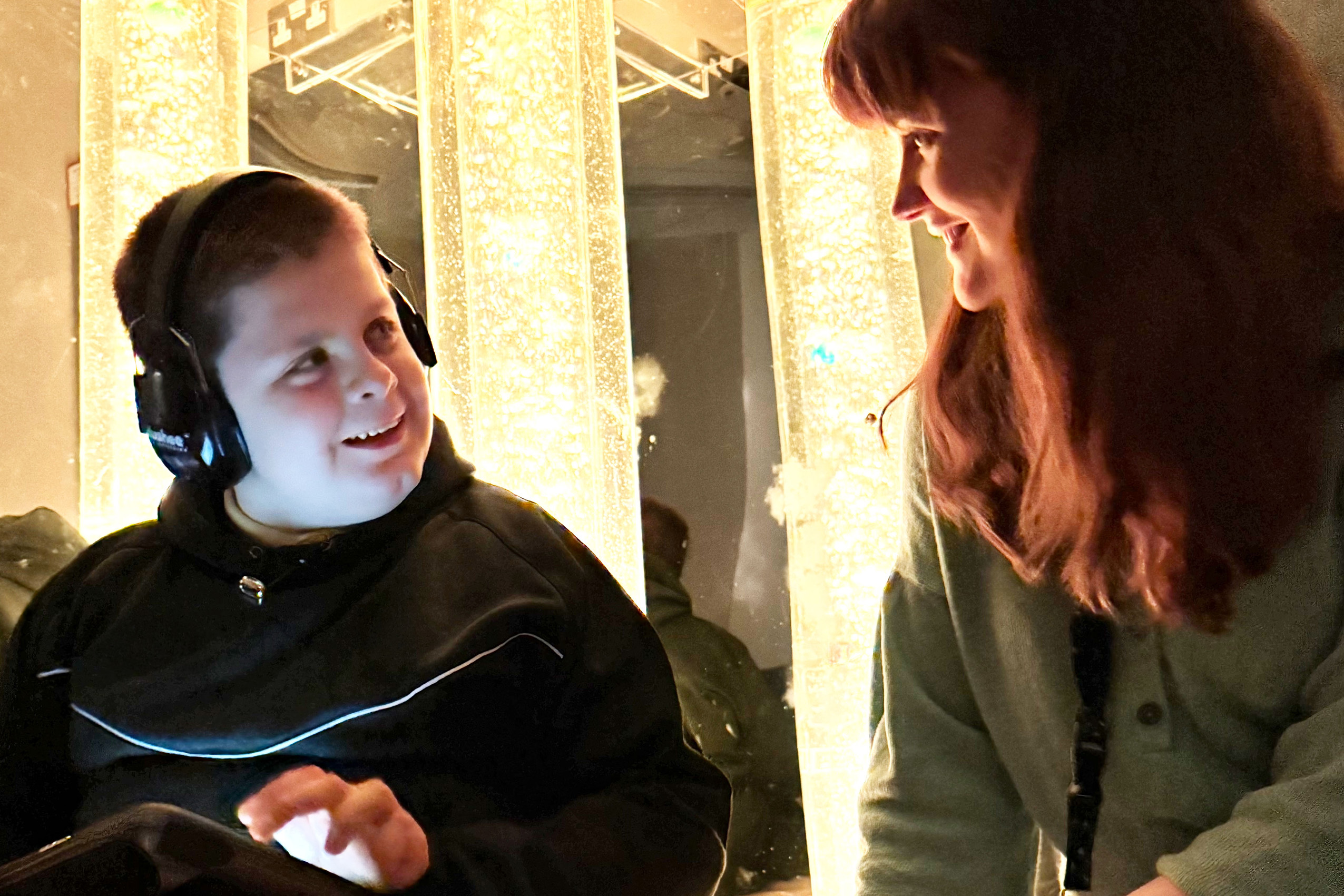 Child in a sensory room looking at a teacher